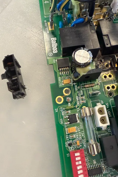 Burnt heater port desoldered from the hot tub control board, beside the scorched pads it came off