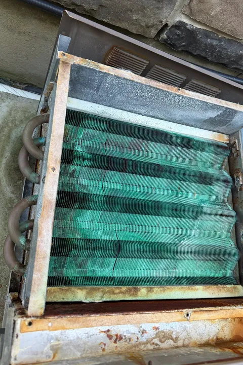 Pool heater heat exchanger in its housing, with the fins corroded green
